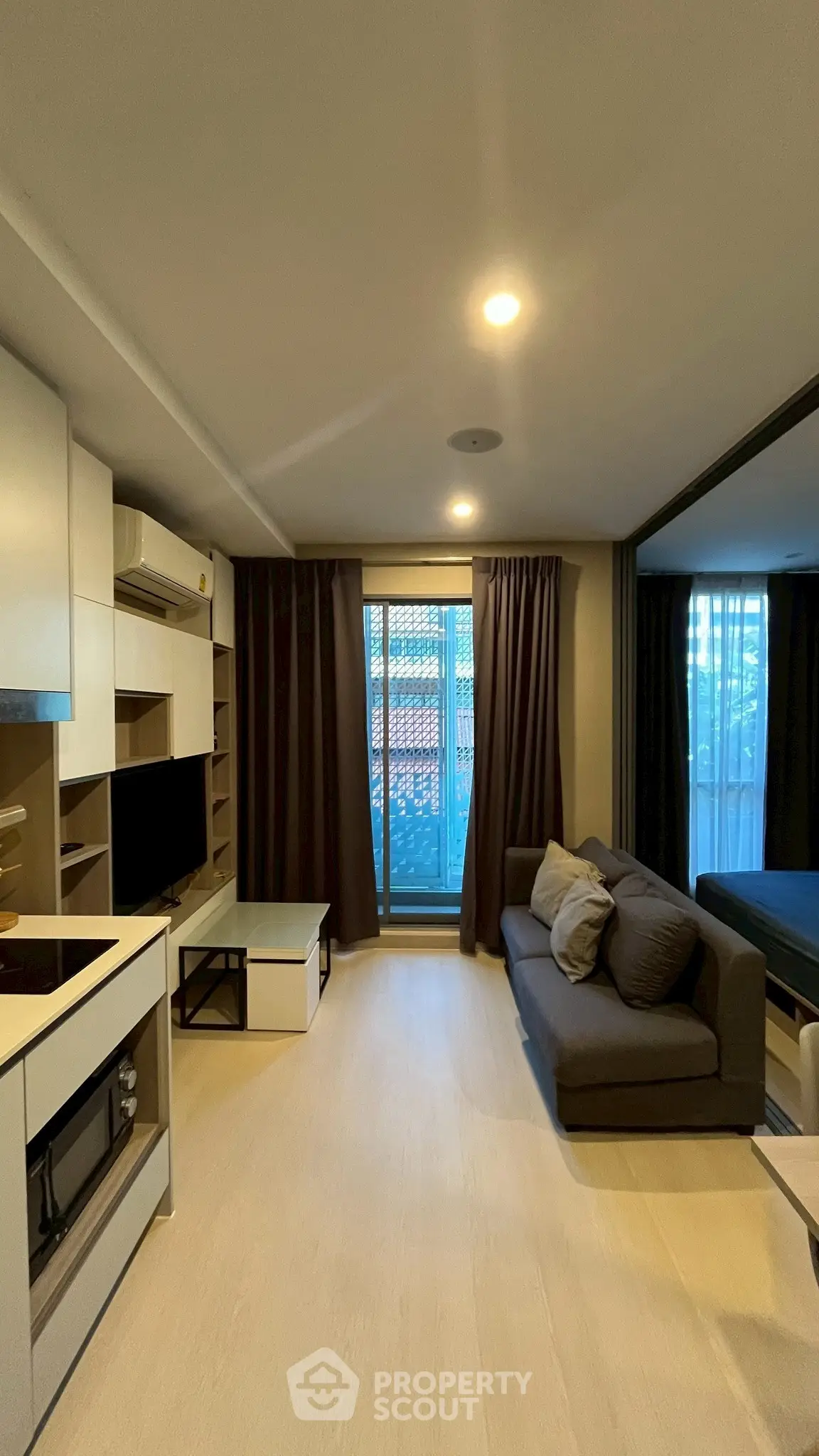 Modern living room with cozy sofa and large window, perfect for relaxation.