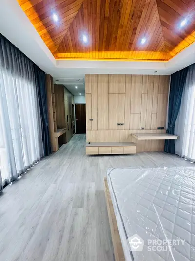 Luxurious bedroom with wooden ceiling and modern design, featuring large windows and elegant lighting.