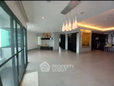 Spacious modern living room with elegant lighting and large windows in luxury apartment.