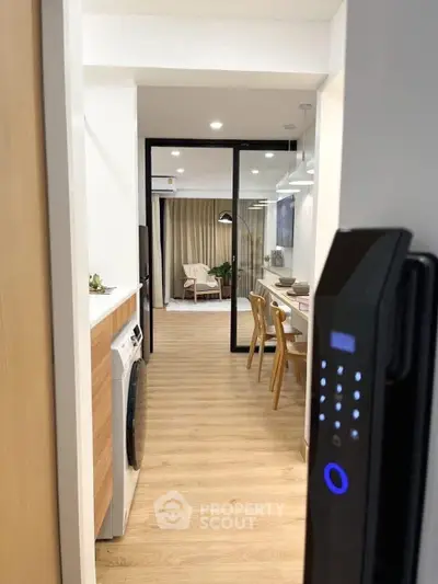 Modern apartment entrance with digital lock, open layout kitchen, and stylish living area.