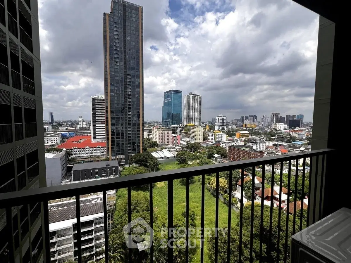 Stunning cityscape view from a high-rise balcony overlooking lush greenery and modern skyscrapers.