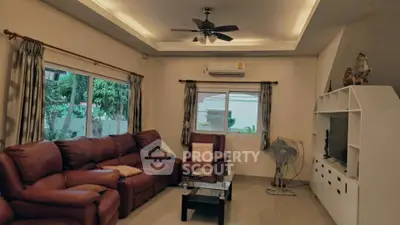 Spacious living room with elegant leather sofas and modern ceiling fan, perfect for relaxation.