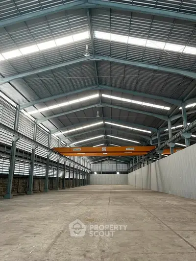 Spacious industrial warehouse with high ceilings and ample natural light, perfect for storage or manufacturing.