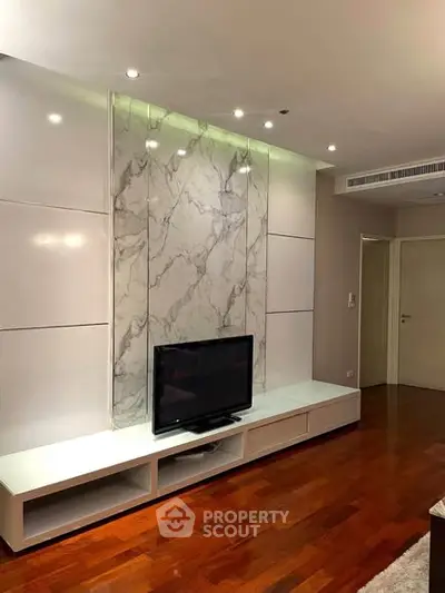 Modern living room with marble accent wall and sleek TV setup