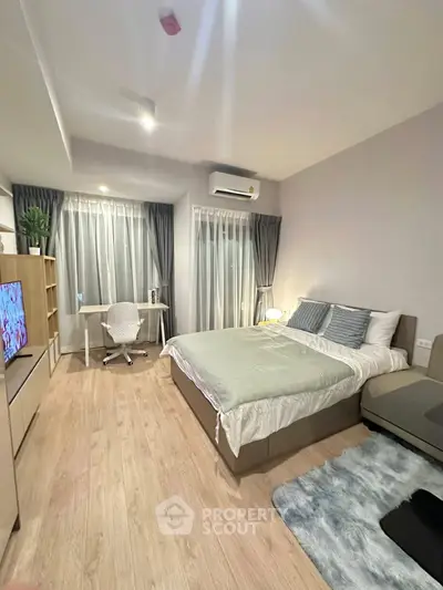 Modern bedroom with cozy decor, featuring a bed, study desk, and stylish curtains.