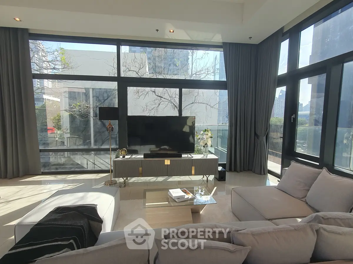 Luxurious living room with floor-to-ceiling windows and modern decor in a high-rise apartment.