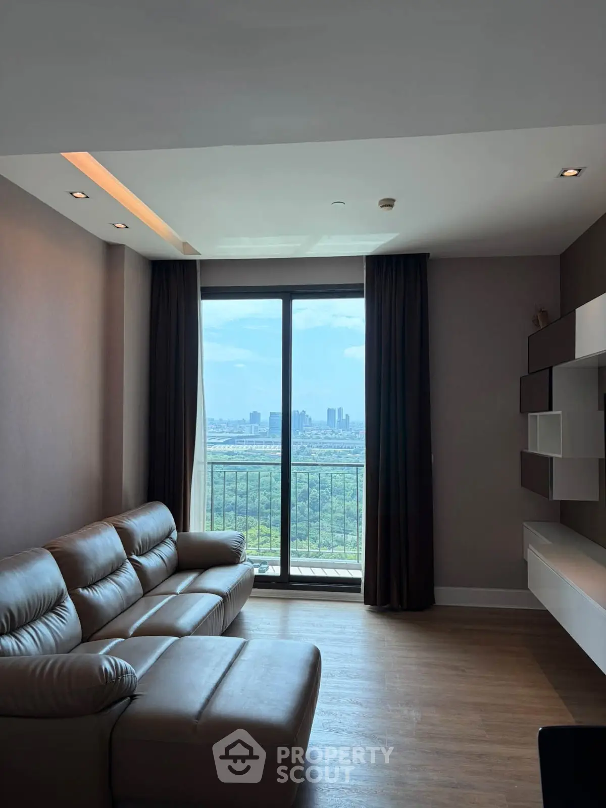 Modern living room with leather sofa and city view through large window