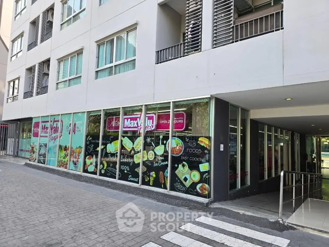 Modern building exterior with retail space and large windows showcasing vibrant signage.