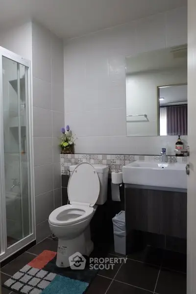 Modern bathroom with sleek design, featuring a glass shower and stylish vanity.