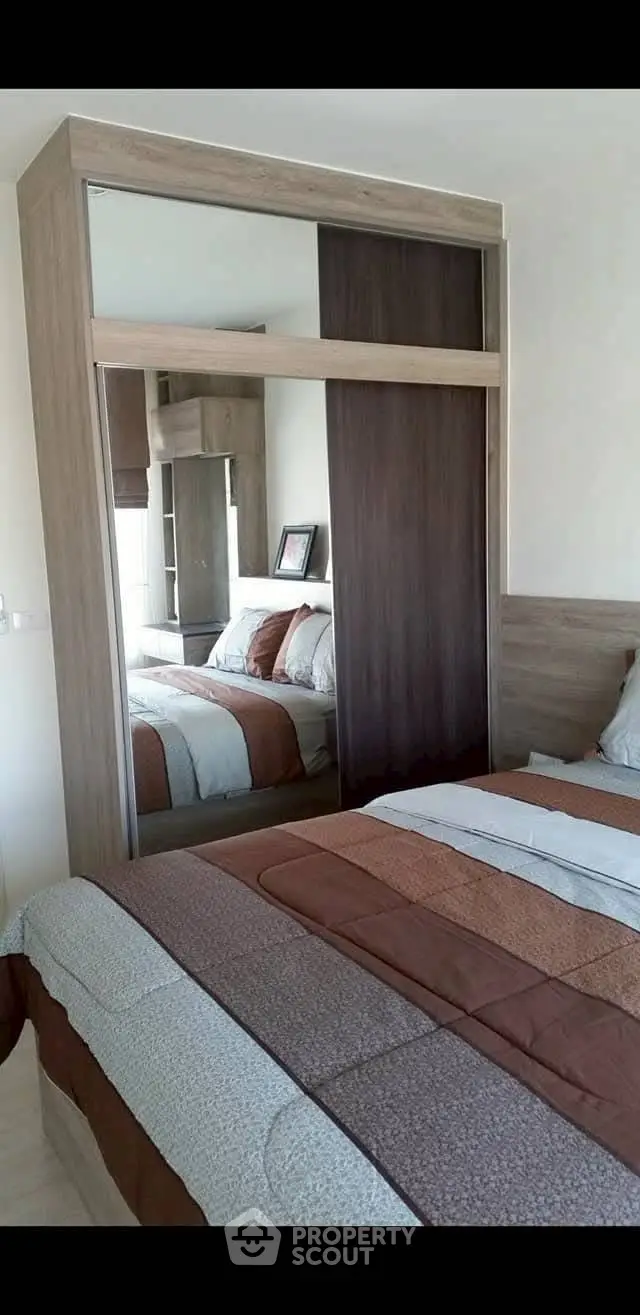 Cozy bedroom with modern wardrobe and stylish bedding in a contemporary apartment.
