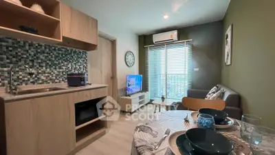 Modern living room with open kitchen, stylish decor, and natural light.