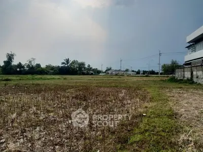 Expansive vacant land with potential for development, surrounded by greenery and clear skies.