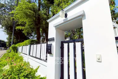 Elegant modern entrance with sleek gate and lush greenery