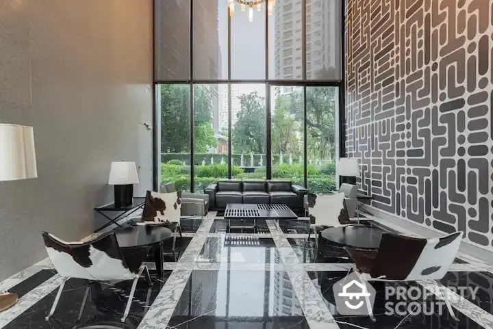 Luxurious living room with high ceiling, marble floors, and floor-to-ceiling windows overlooking lush greenery.