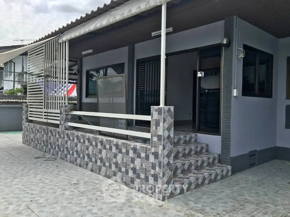 Charming single-story home with tiled exterior and inviting front porch