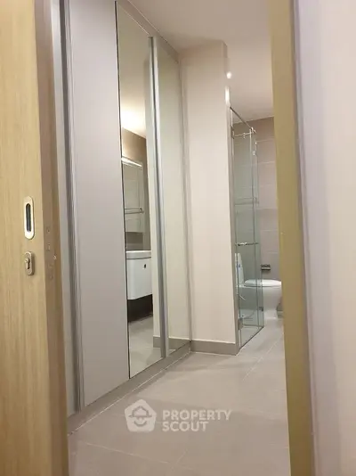 Modern bathroom with glass shower and sleek cabinetry in a contemporary apartment.