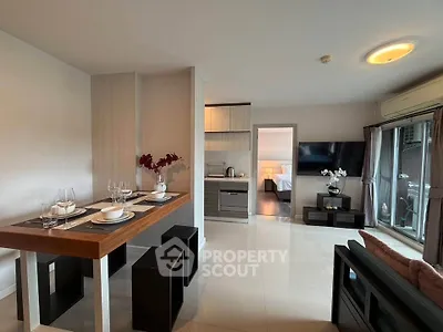 Modern open-plan living room with dining area and sleek kitchen in a stylish apartment.