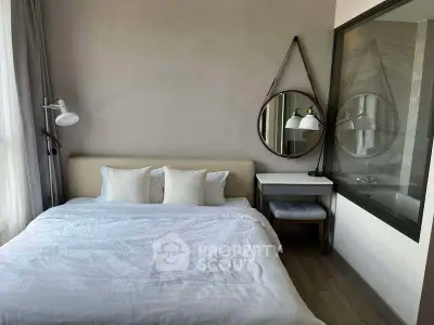 Modern bedroom with stylish decor and large window for natural light.