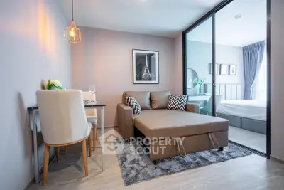 Modern living room with stylish decor and cozy seating area adjacent to a bedroom.