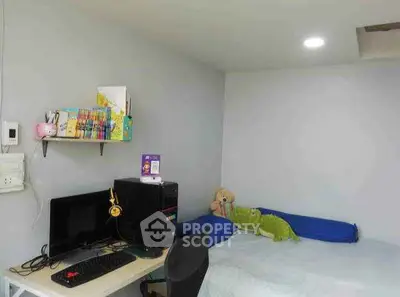 Cozy bedroom with computer desk and plush toys, ideal for a student or young professional.