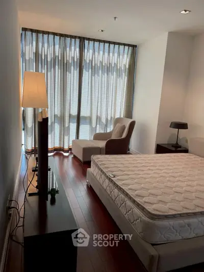 Spacious bedroom with large windows and elegant furnishings