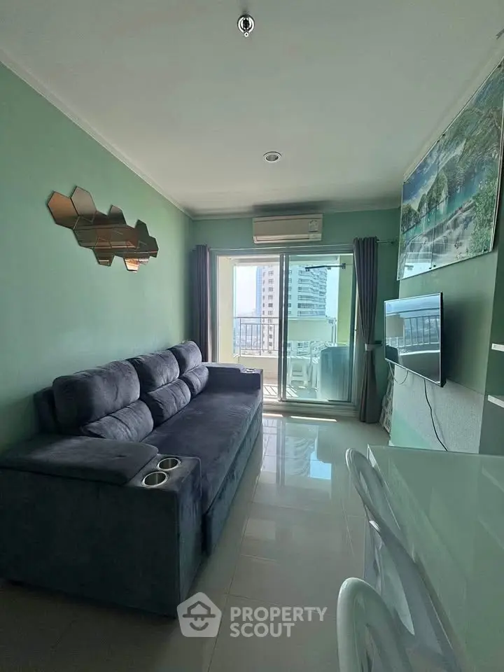Modern living room with stylish decor and city view balcony in high-rise apartment.