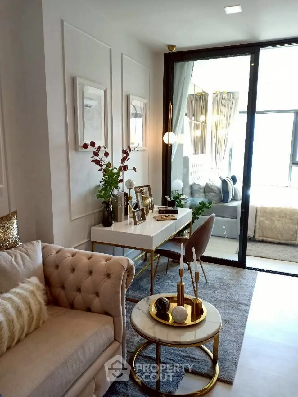 Luxurious living room with elegant decor and cozy seating, featuring a stylish workspace and large windows.