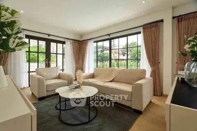 Elegant living room with large windows and cozy seating area