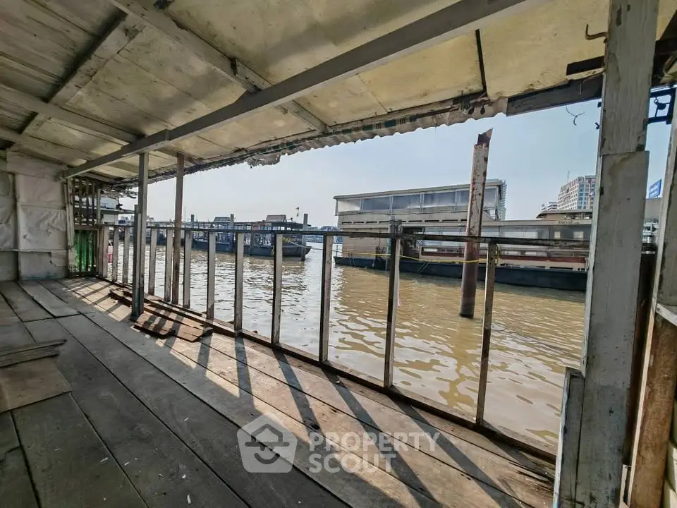 Riverside wooden deck with scenic water view and urban backdrop, perfect for serene living or commercial use.