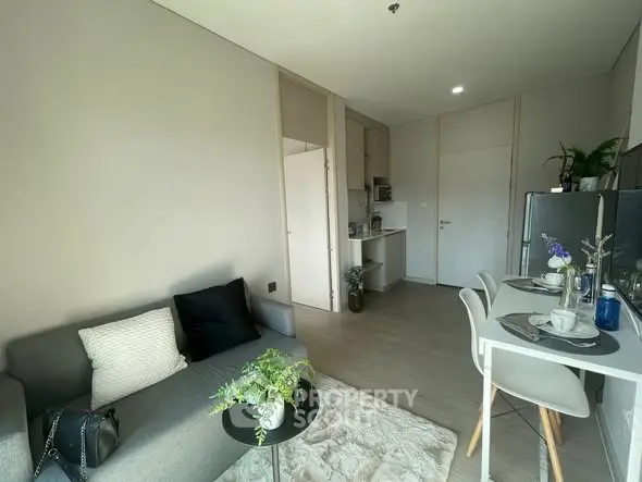 Modern living room with cozy seating and dining area in open layout apartment.