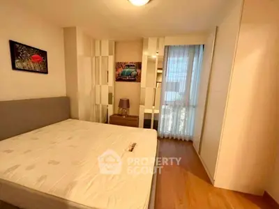 Cozy bedroom with wooden flooring and modern decor in a stylish apartment.
