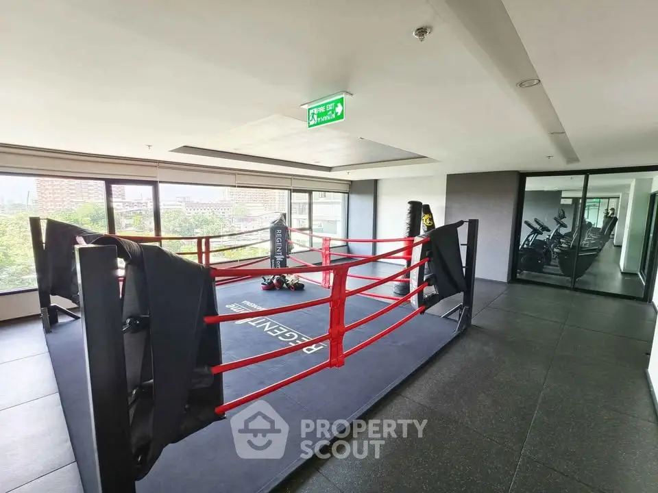 Modern gym with boxing ring and fitness equipment in a high-rise building
