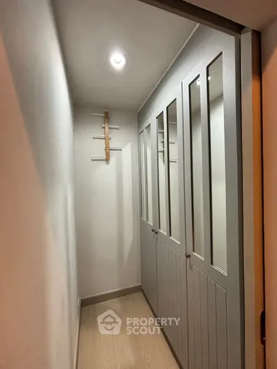 Spacious walk-in closet with elegant mirrored doors and ample storage space.