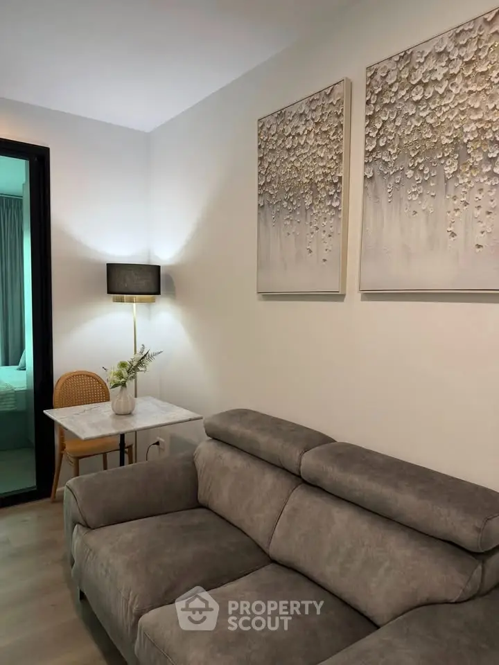 Modern living room with stylish gray sofa and elegant wall art, perfect for cozy relaxation.