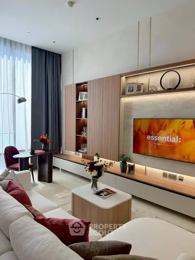 Elegant living room with modern decor, large TV, and stylish shelving unit.