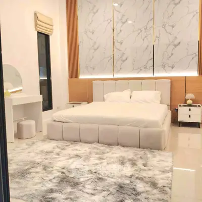 Luxurious bedroom with plush bed, elegant decor, and ambient lighting for a serene retreat.