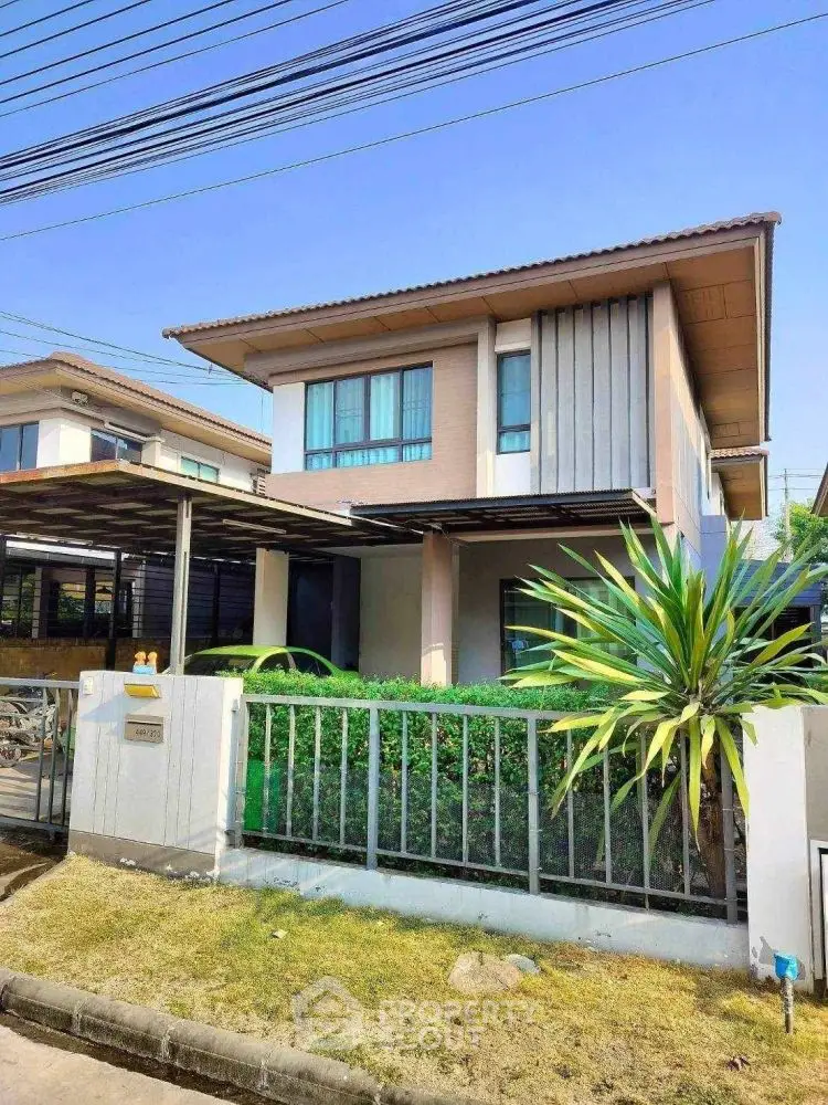 Modern two-story house with lush garden and stylish facade in a suburban neighborhood.