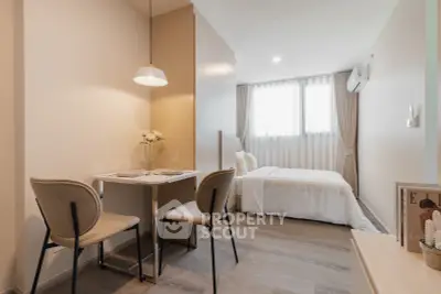 Modern studio apartment with cozy dining area and stylish bedroom setup.