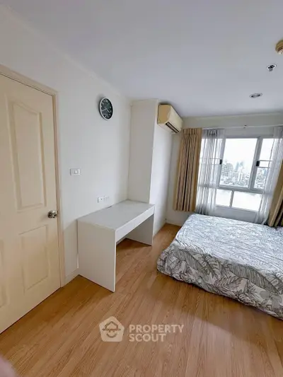 Spacious bedroom with city view, featuring a large window, wooden flooring, and modern decor.