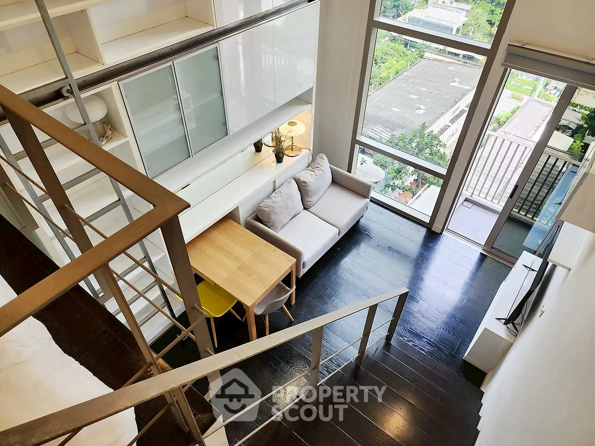 Modern loft apartment with mezzanine, large windows, and stylish interior design.