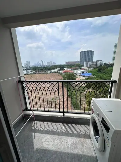 Charming balcony with city view and washing machine, perfect for urban living.