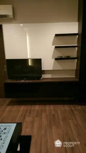 Modern living room with sleek TV unit and wooden flooring