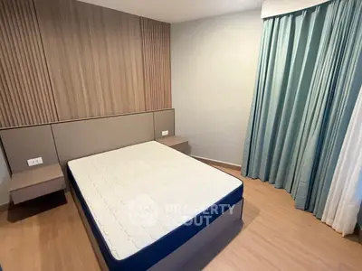 Modern bedroom with minimalist design and stylish wood paneling, featuring a comfortable bed and elegant curtains.