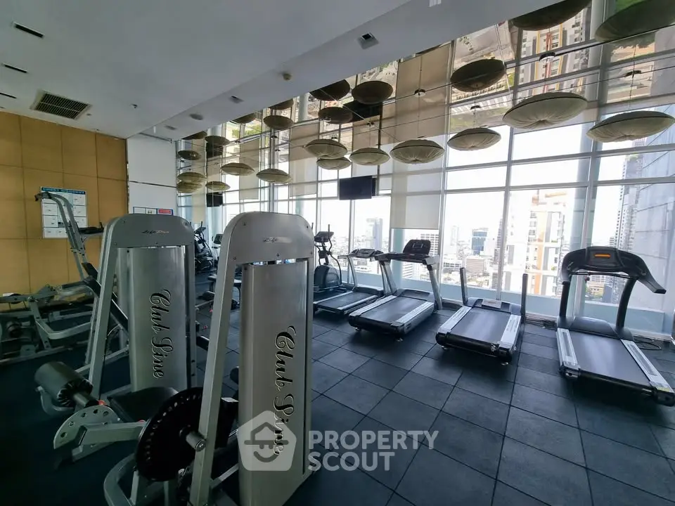 Luxurious high-rise gym with modern equipment and stunning city views.