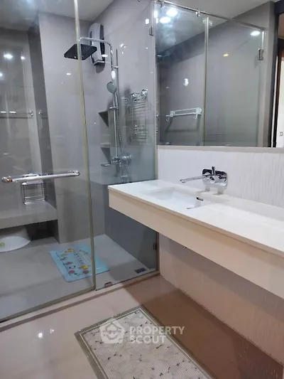 Modern bathroom with glass shower enclosure and sleek double sink vanity.