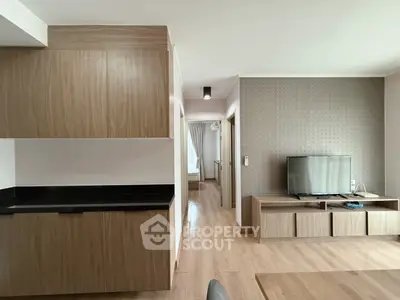 Modern living room with sleek wooden furniture and flat-screen TV