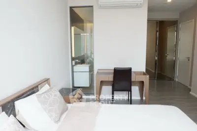 Modern bedroom with ensuite bathroom and sleek furnishings in a contemporary apartment.