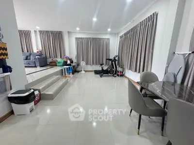 Spacious modern living room with exercise equipment and dining area