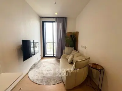 Cozy modern living room with stylish sofa and wall-mounted TV, featuring a large window with a view.