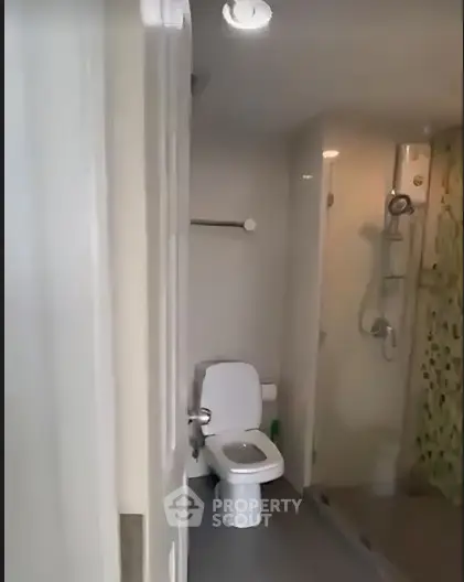 Compact bathroom with modern shower and toilet in a cozy apartment.